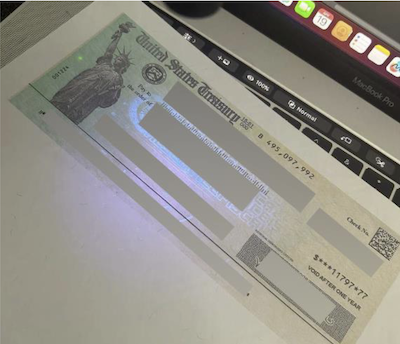 Example of a digitally altered treasury check containing an ultraviolet overprinting pattern.